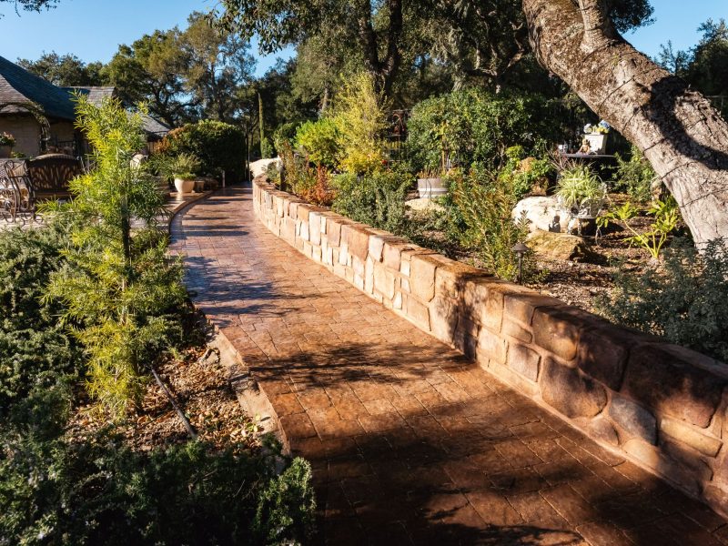 Custom paver walkway in Paso Robles with decorative stone urn and integrated landscape lighting.