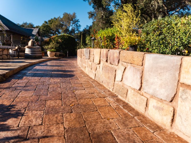 Curved stamped concrete paver walkway in Paso Robles leading toward an elevated patio and outdoor seating space.