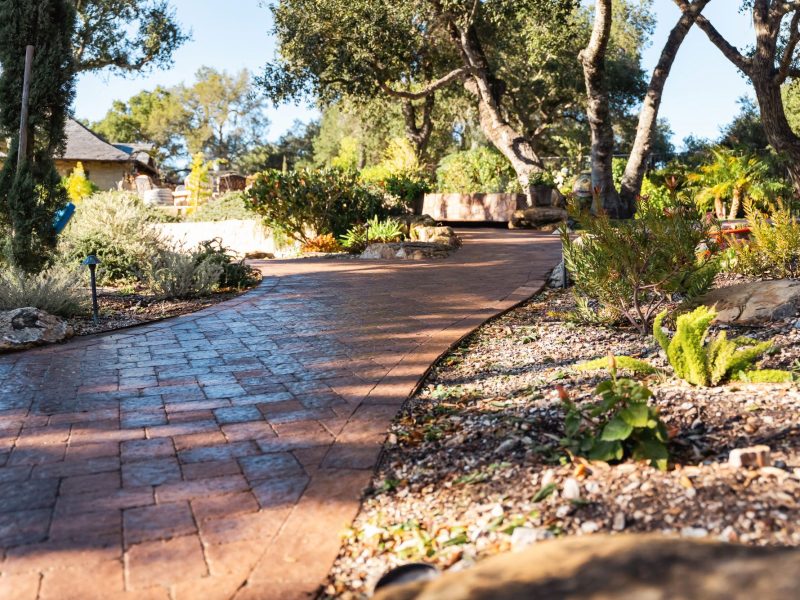 Low angle view of stone retaining wall alongside stamped concrete paver walkway in Paso Robles.