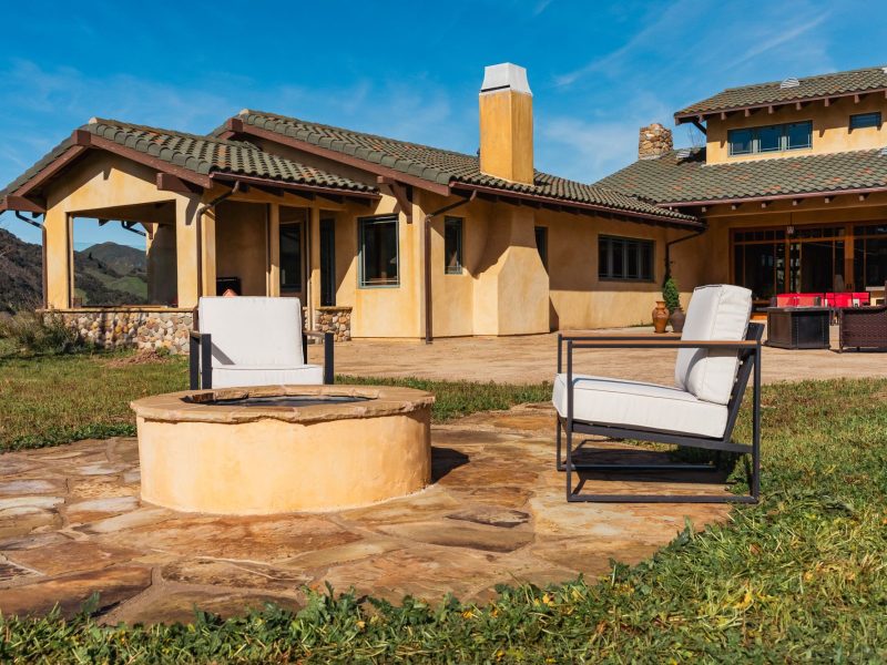 Circular stone fire pit installed in a San Luis Obispo backyard outdoor living space.