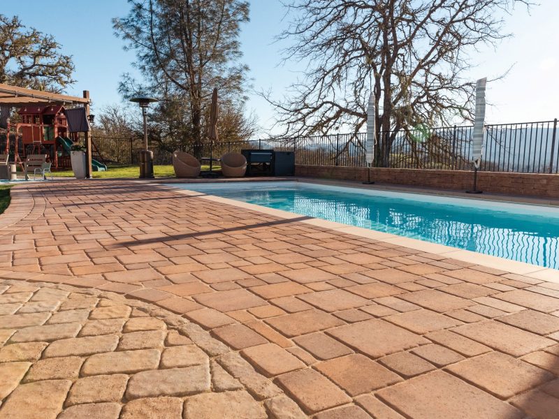 San Luis Obispo pool renovation showcasing expanded paver pool deck, upgraded hardscape, and outdoor family recreation space.