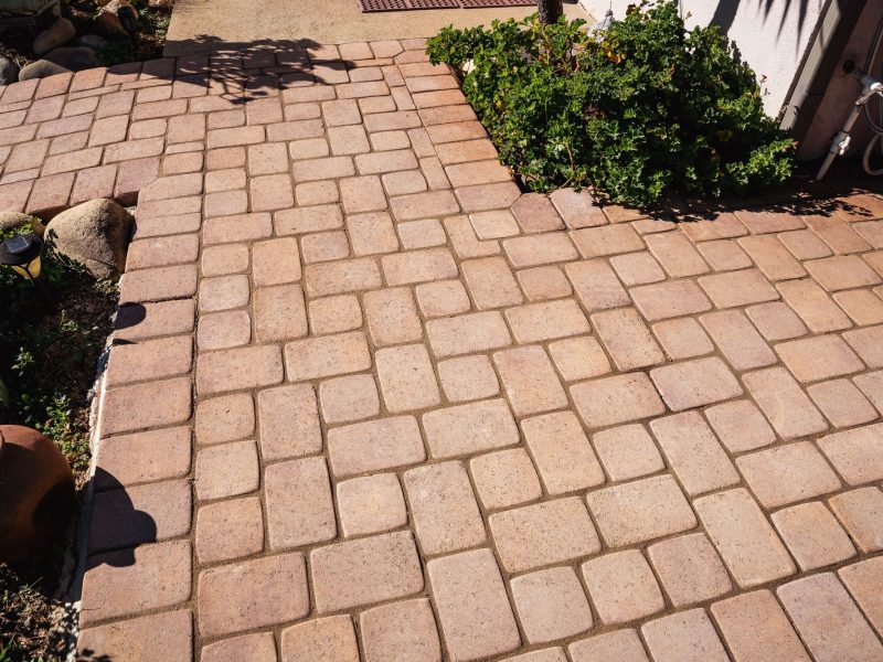 Front yard hardscape installation in San Luis Obispo featuring interlocking pavers and natural stone edging.