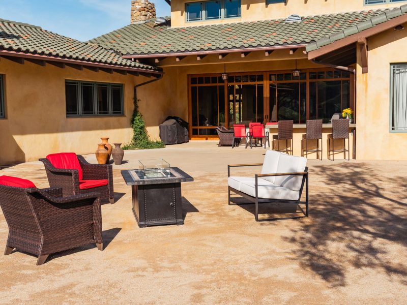Custom outdoor living patio in San Luis Obispo featuring modern lounge seating and a square fire pit table.
