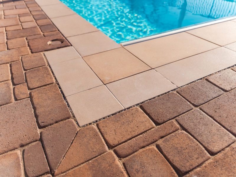Close-up of pool coping and contrasting paver border installed during a San Luis Obispo pool renovation project.