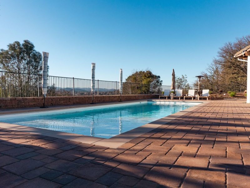 Custom pool transformation in San Luis Obispo featuring a rectangular swimming pool with upgraded paver deck and scenic hillside views.