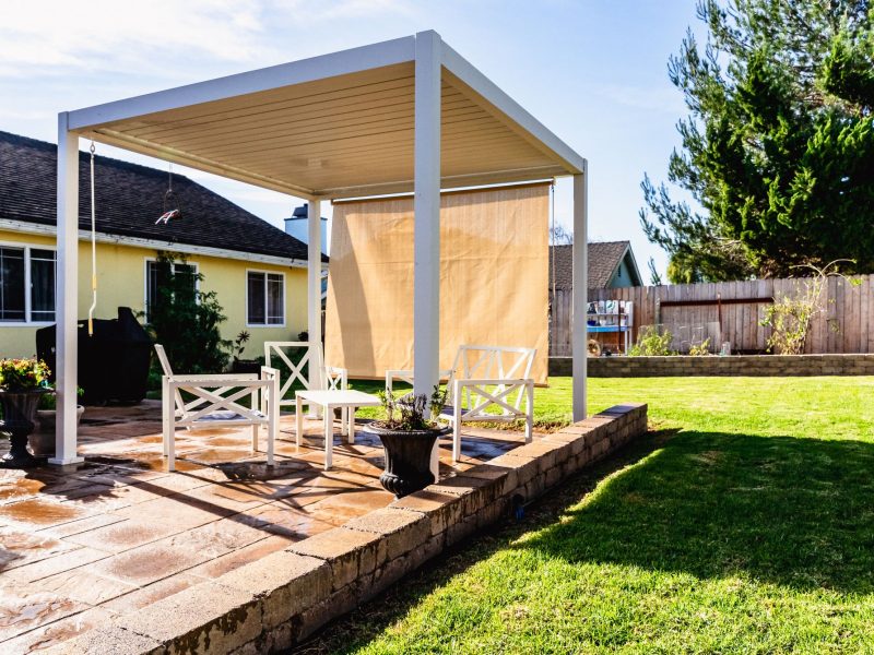 Custom pergola structure over a stamped concrete paver patio surrounded by lawn and raised garden beds in Santa Maria.