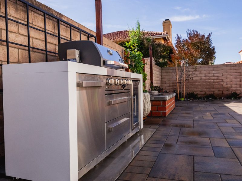 Custom outdoor kitchen with stainless steel grill installed on a Santa Maria paver patio.