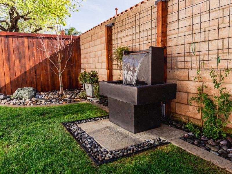 Contemporary black water feature fountain installed along a landscaped side yard in Santa Maria.