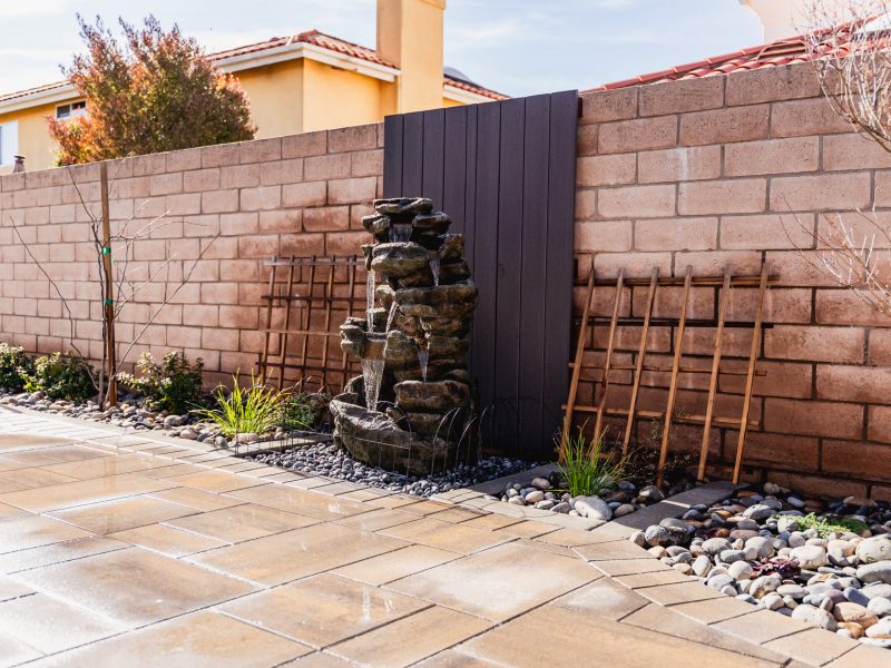 Natural-style rock waterfall water feature integrated into a Santa Maria backyard side yard landscape.