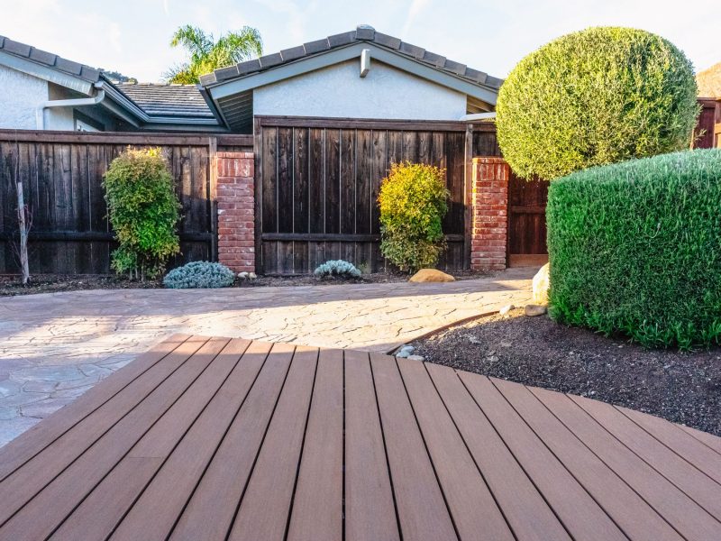 Stamped concrete walkway connecting to a composite deck area in a Shell Beach backyard landscape design.