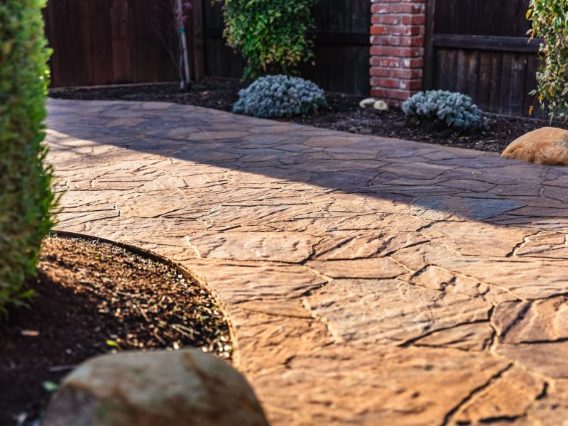 Close-up of stamped concrete walkway with natural flagstone pattern installed in Shell Beach.